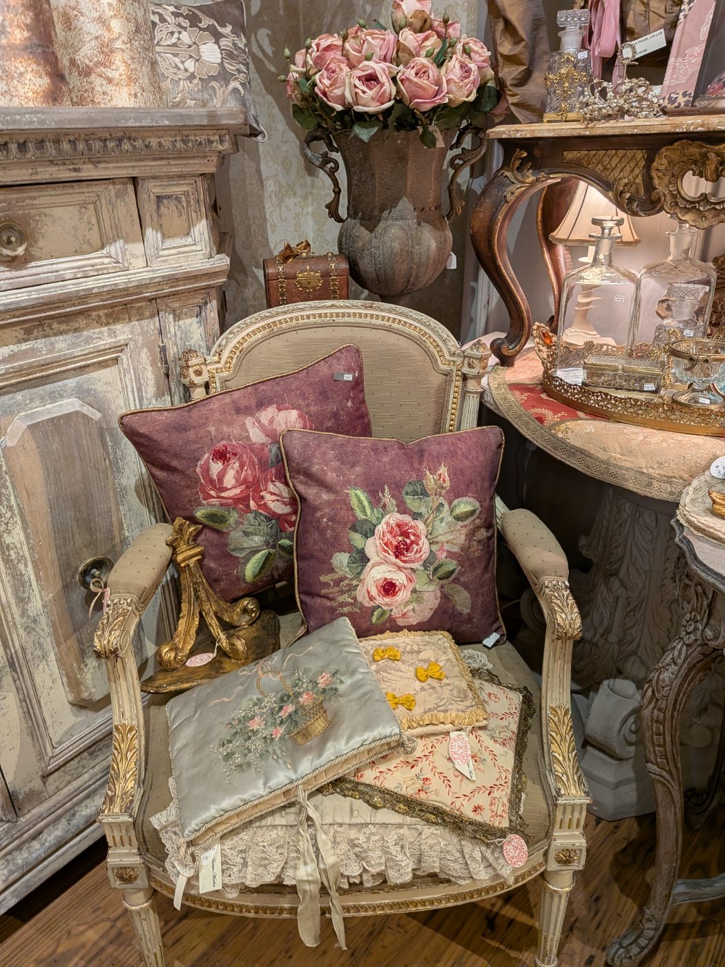 Authentic European antique carved cabinet and rose tapestry pillows at our Plymouth, MI shop