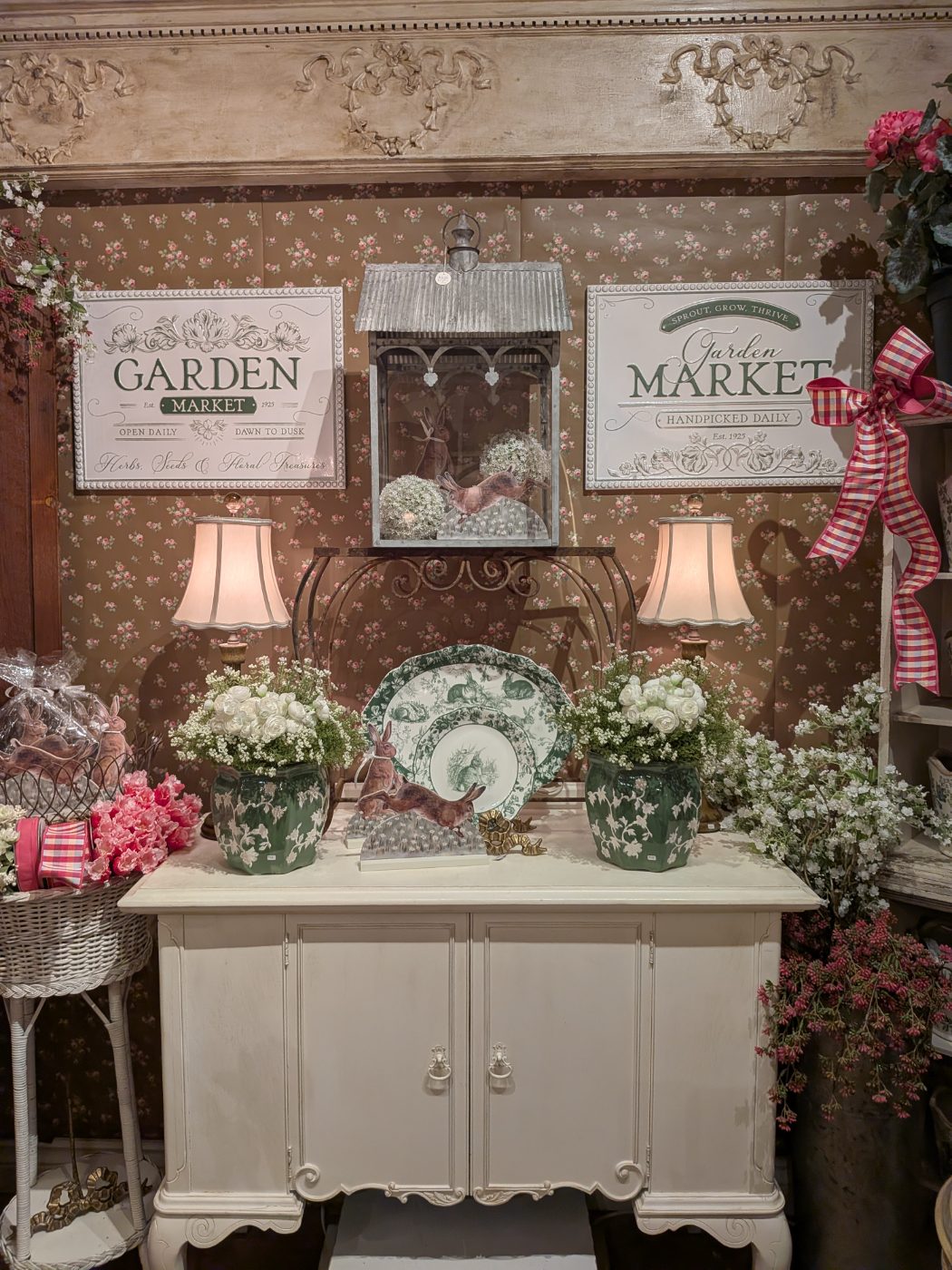 Garden Market signs above a cream cabinet with toile cachepots and spring florals available in downtown Plymouth