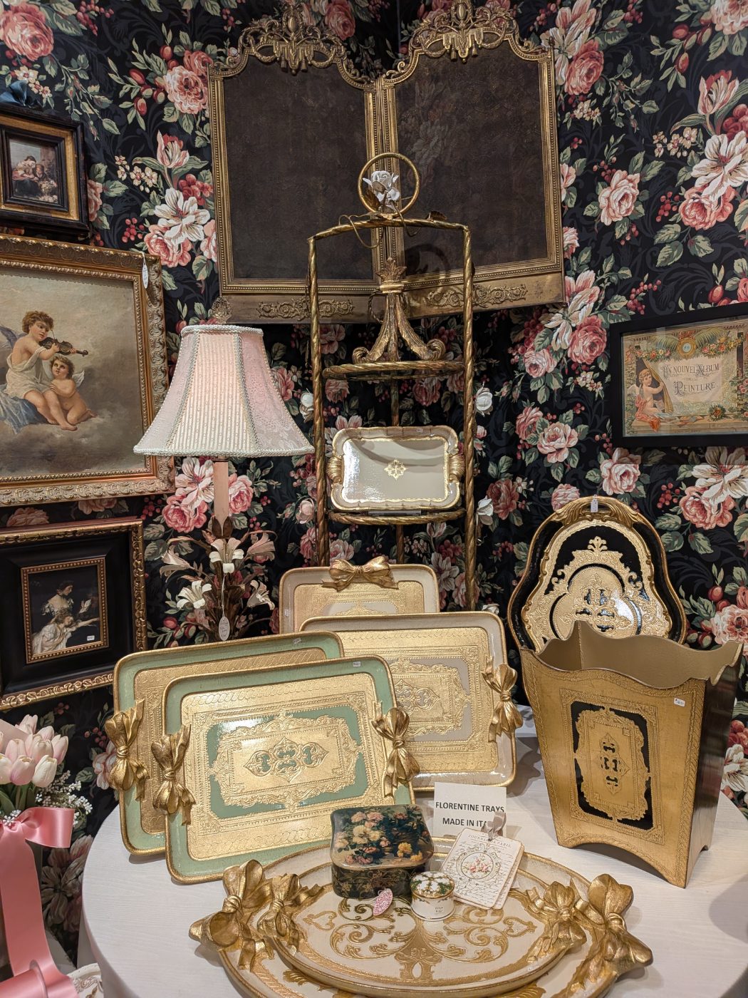 Gilded Florentine trays made in Italy against rose floral wallpaper