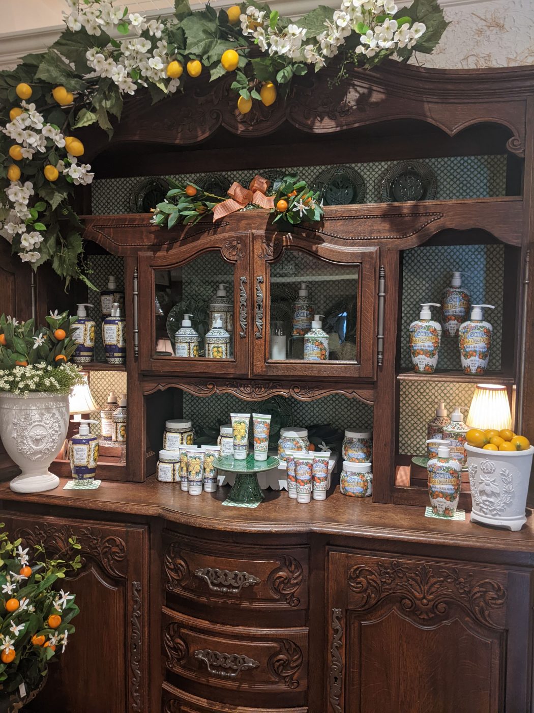 Italian and French soaps and hand creams on a carved oak hutch with lemons