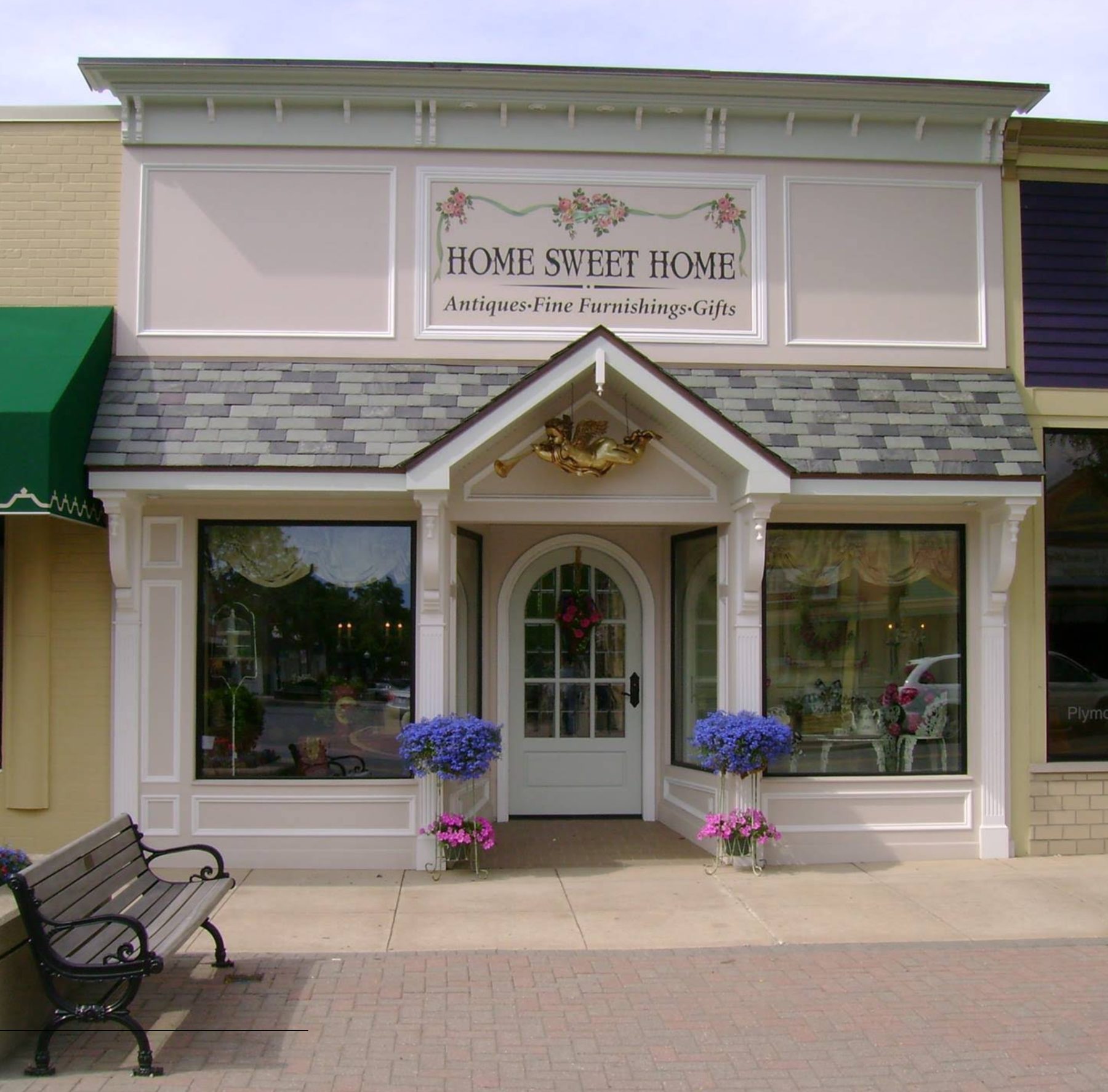 The Home Sweet Home storefront at 852 W Ann Arbor Trail — a custom 19th-century facade with flower baskets at the windows